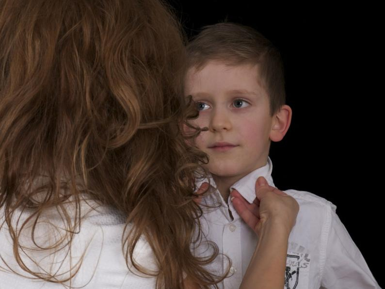 Mother helping a student get ready for school with their uniform