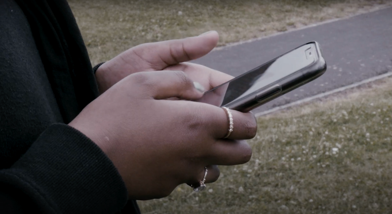 Young person's hand holding a smart phone