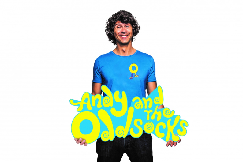 Andy Day standing with Andy and the Odd Socks logo