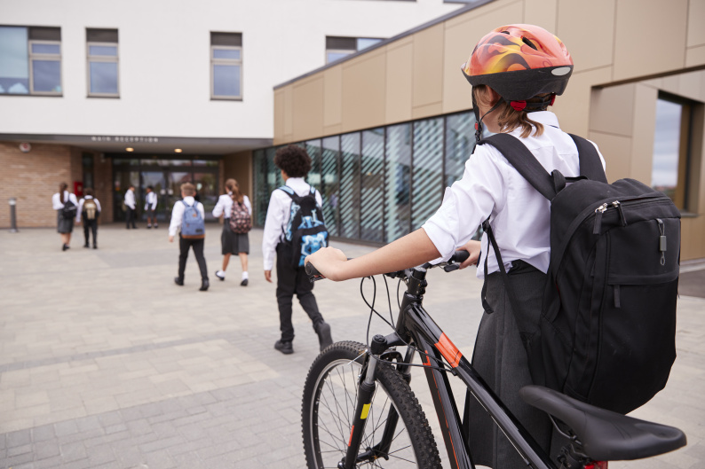 Pupil with bike going into a school 
